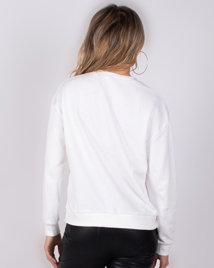 Achteraanzicht van een vrouw in een witte trui uit de Studio AW25-26 collectie en zwarte leren broek.