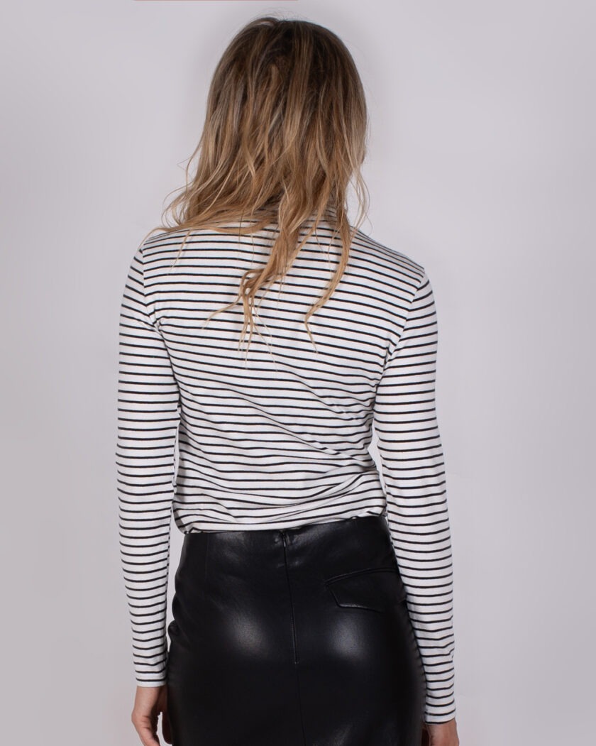 Vrouw van achteren in een zwart-wit gestreepte top en zwarte leren rok uit de Studio AW25-26 collectie.