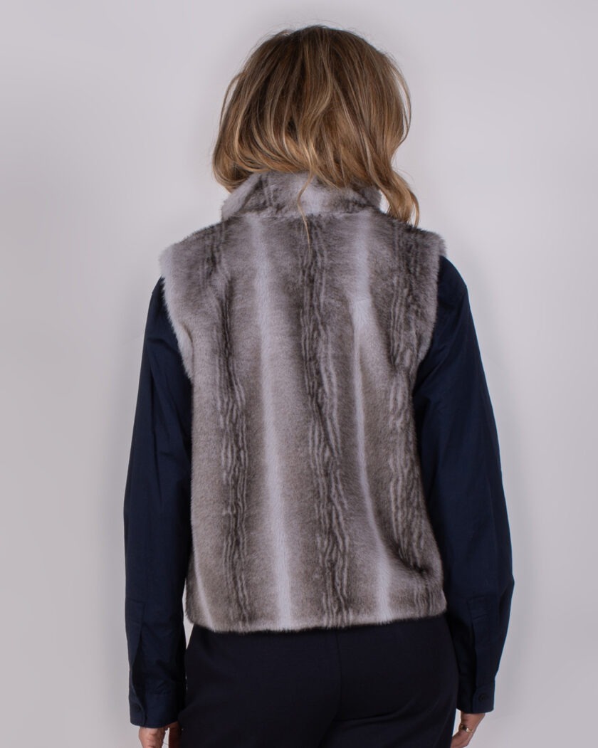 Achteraanzicht van een persoon die een grijsbruine Studio AW25-26-114 bontlook bodywarmer draagt over een donkerblauwe blouse.