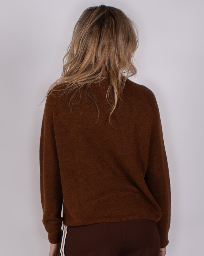 Vrouw van achteren gezien met los haar, gekleed in een bruine trui uit de Studio AW25-26-117 collectie.