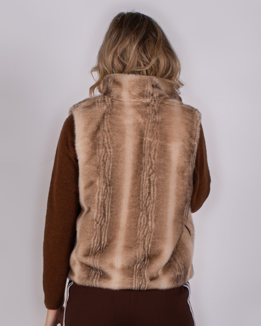 Achteraanzicht van een model met een beige faux-fur bodywarmer uit de Studio AW25-26 collectie.