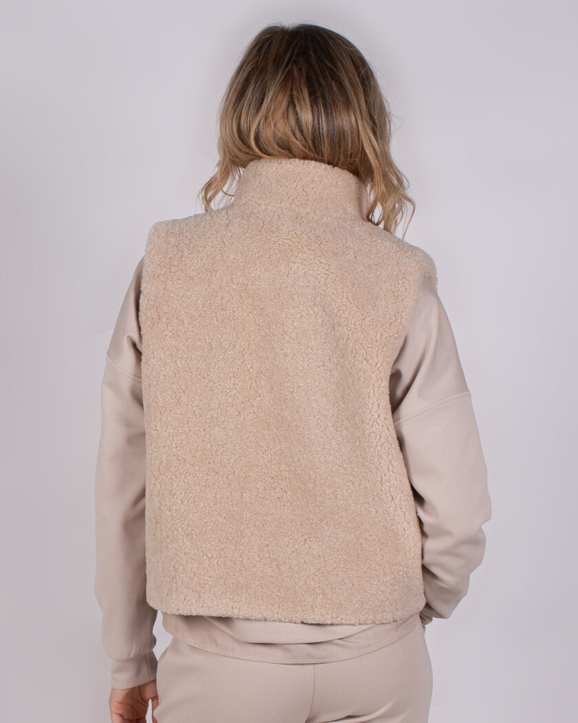 Achteraanzicht van een vrouw in een beige fleece bodywarmer uit de Studio AW25-26-196 collectie.
