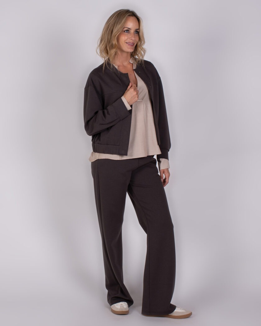 Vrouw draagt een comfortabele, donkerbruine Studio AW25-26-206 outfit met wijde broek en bijpassend jasje.