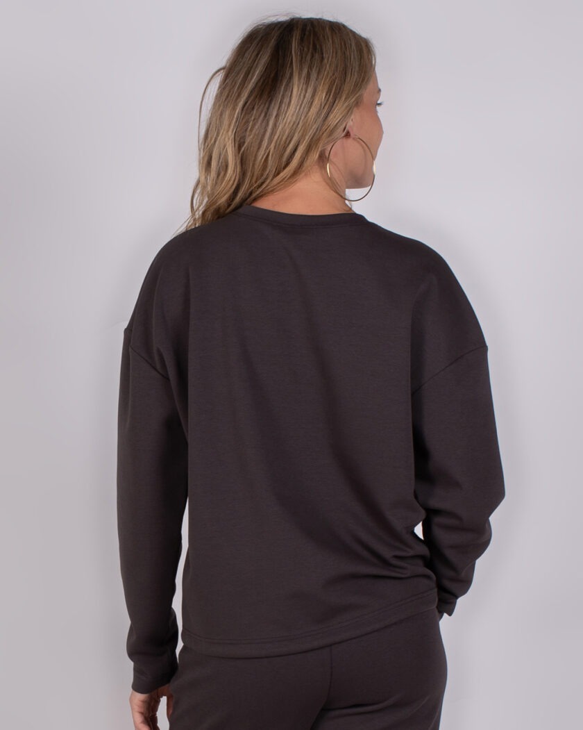Achteraanzicht van een vrouw die een donkerbruine Studio AW25-26-213 sweater en bijpassende broek draagt.