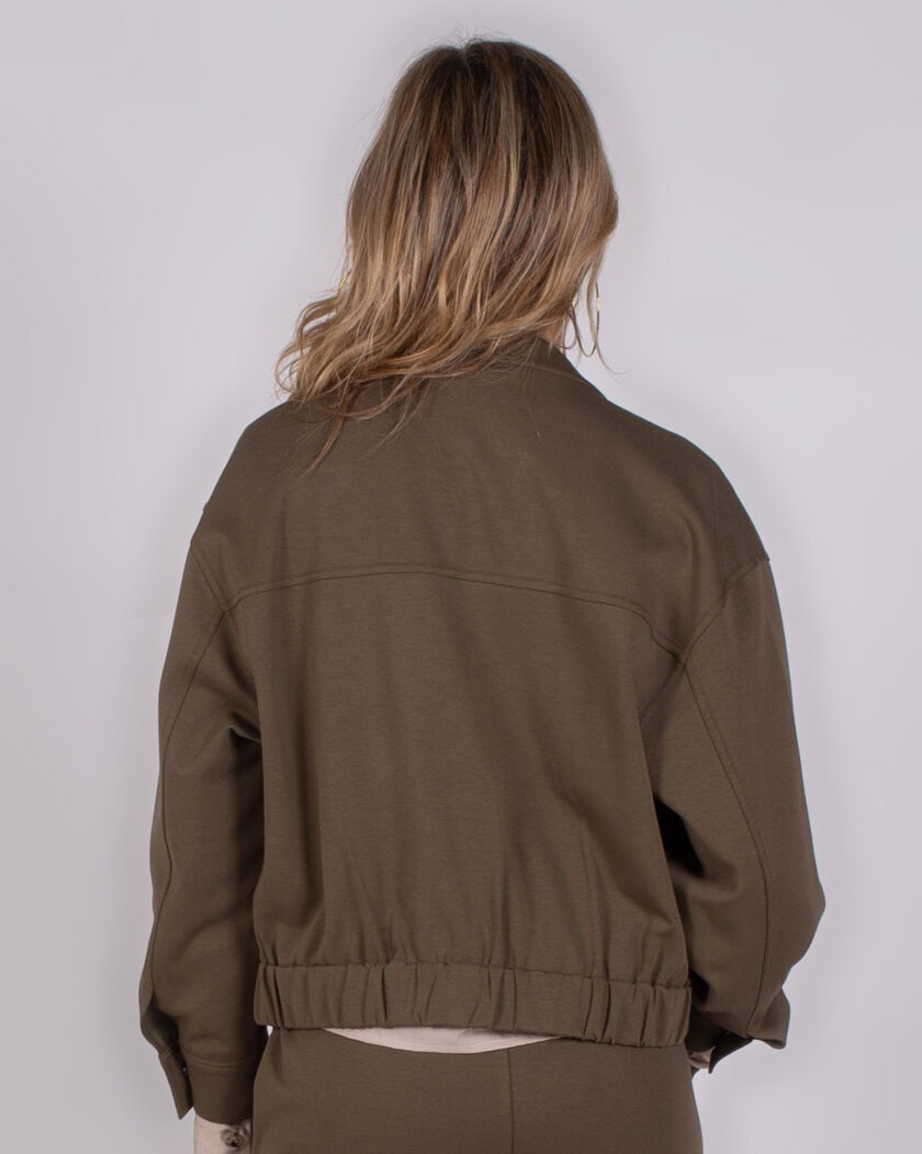 Achteraanzicht van een model dat een bruine Studio AW25-26-242 jas met elastische taille draagt.
