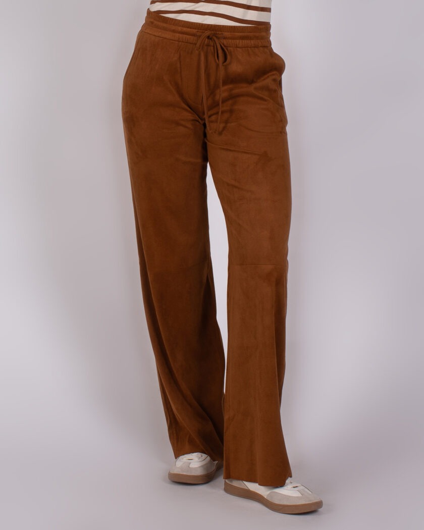 Model draagt een bruine Studio AW25-26-254 broek met wijde pijpen en elastische tailleband met trekkoord.
