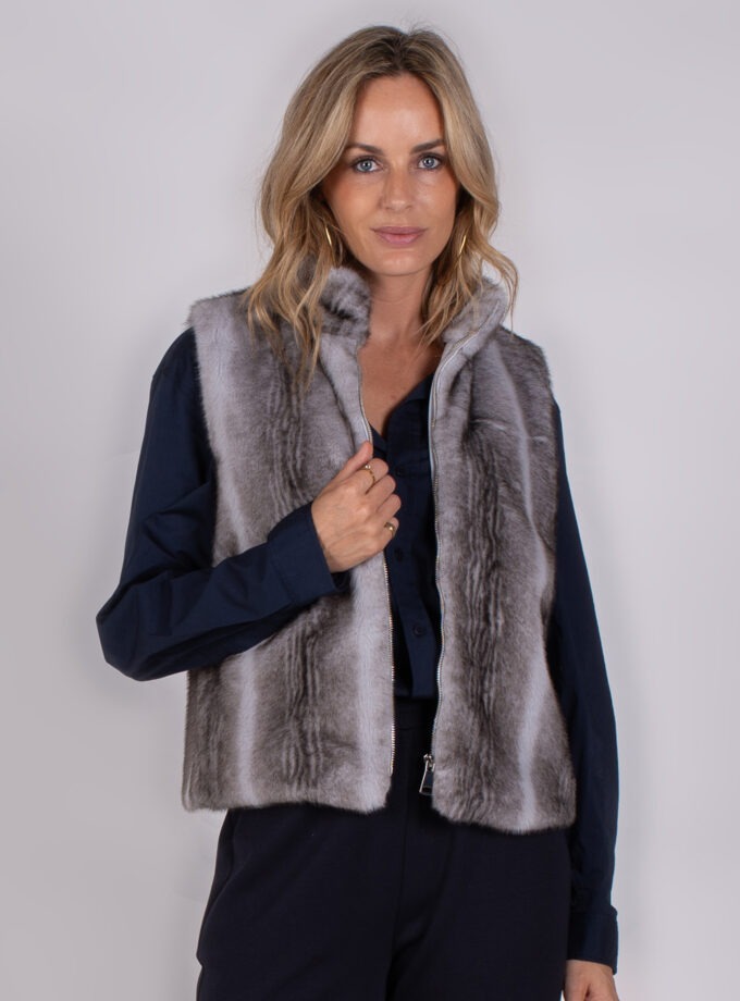 Vrouw draagt een grijs faux fur bodywarmer met ritssluiting uit de Studio AW25-26 collectie.
