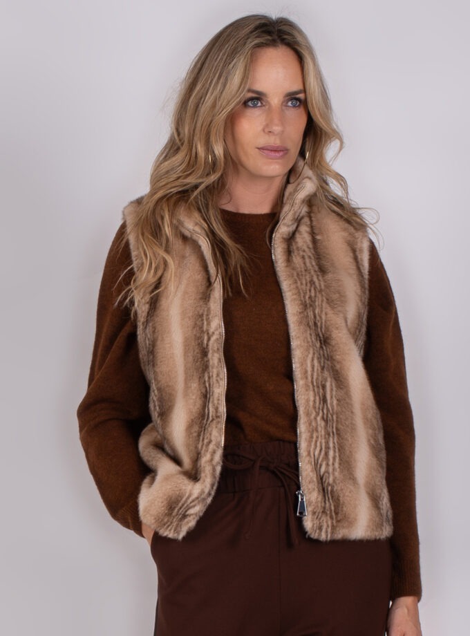 Vrouw draagt een bruine outfit met een zachte, lichtbruine bontlook bodywarmer uit de Studio AW25-26-28 collectie.