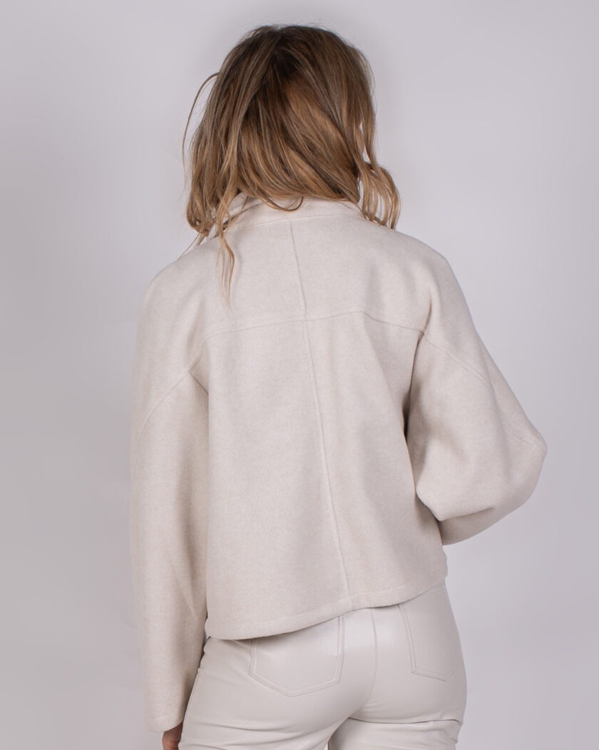 Model van achteren in een licht beige Studio AW25-26-310 jack en bijpassende broek.