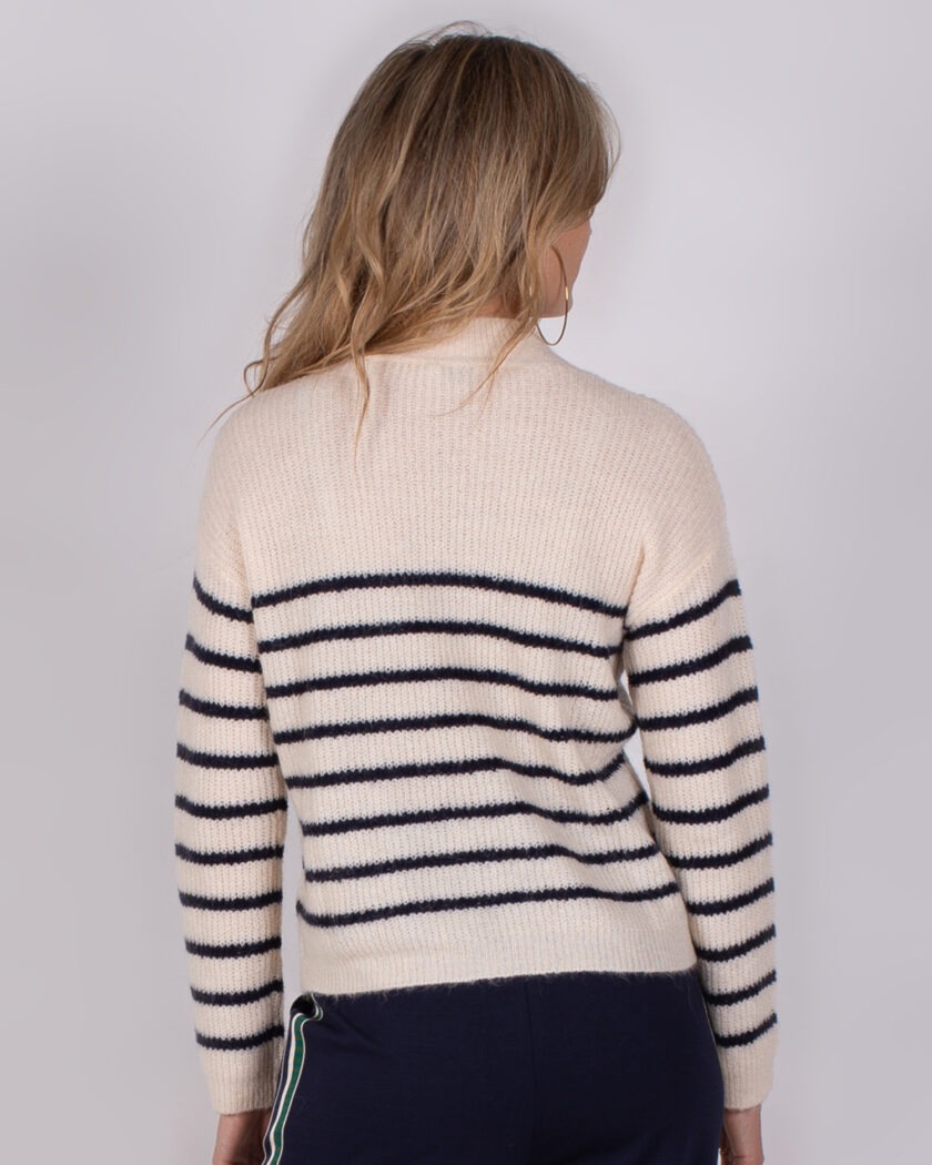 Vrouw van achteren met crèmekleurige trui met donkerblauwe strepen uit de Studio AW25-26 collectie.