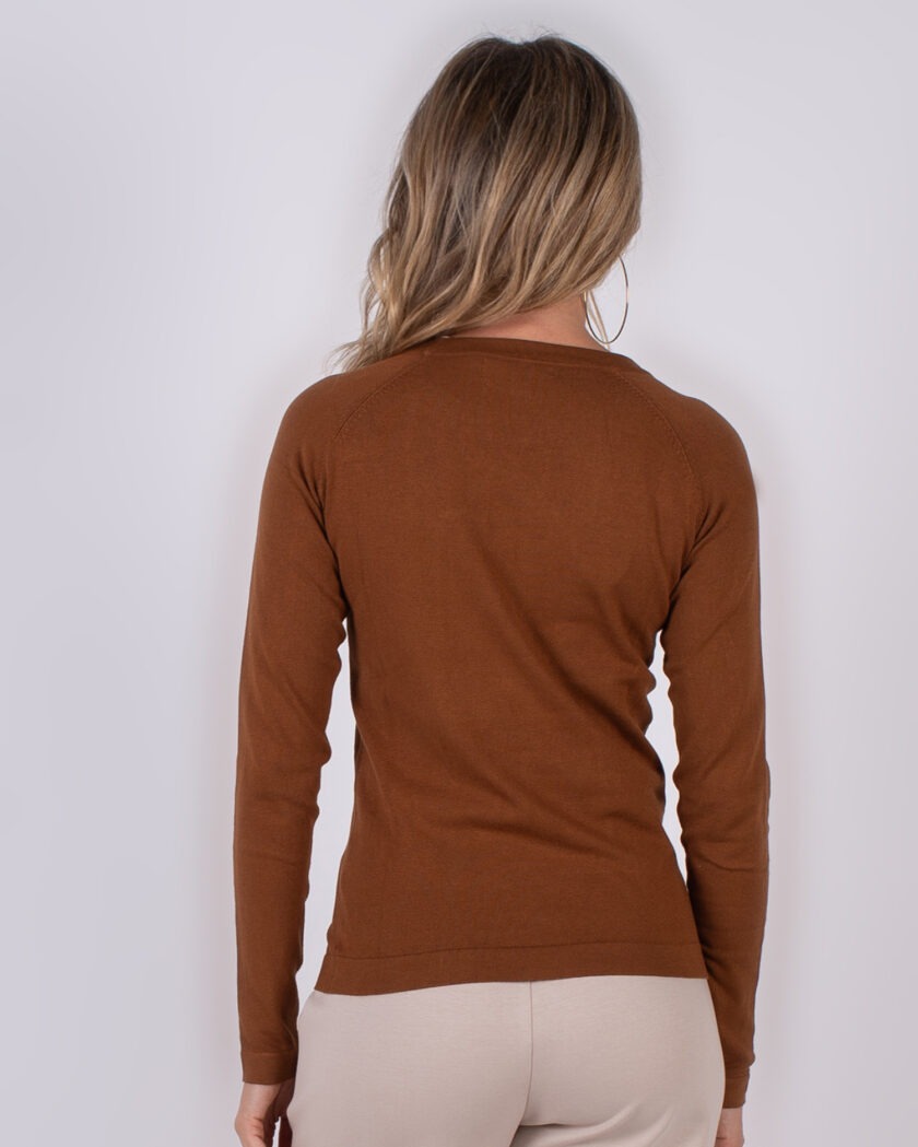 Vrouw met lang blond haar draagt een bruin, lange mouwen shirt uit de Studio AW25-26 collectie, gezien van achteren.