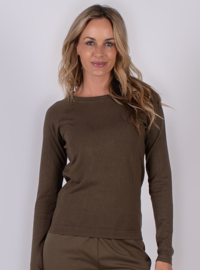 Vrouw poseert in een bruine, lange mouwen top en bijpassende broek uit de Studio AW25-26 collectie.