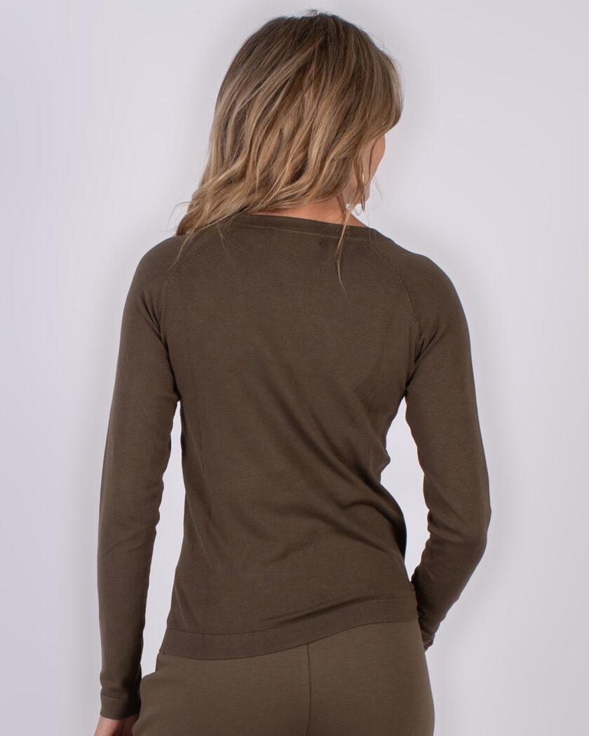 Achteraanzicht van een vrouw in een olijfgroene, lange mouwen top en bijpassende broek uit de Studio AW25-26 collectie.
