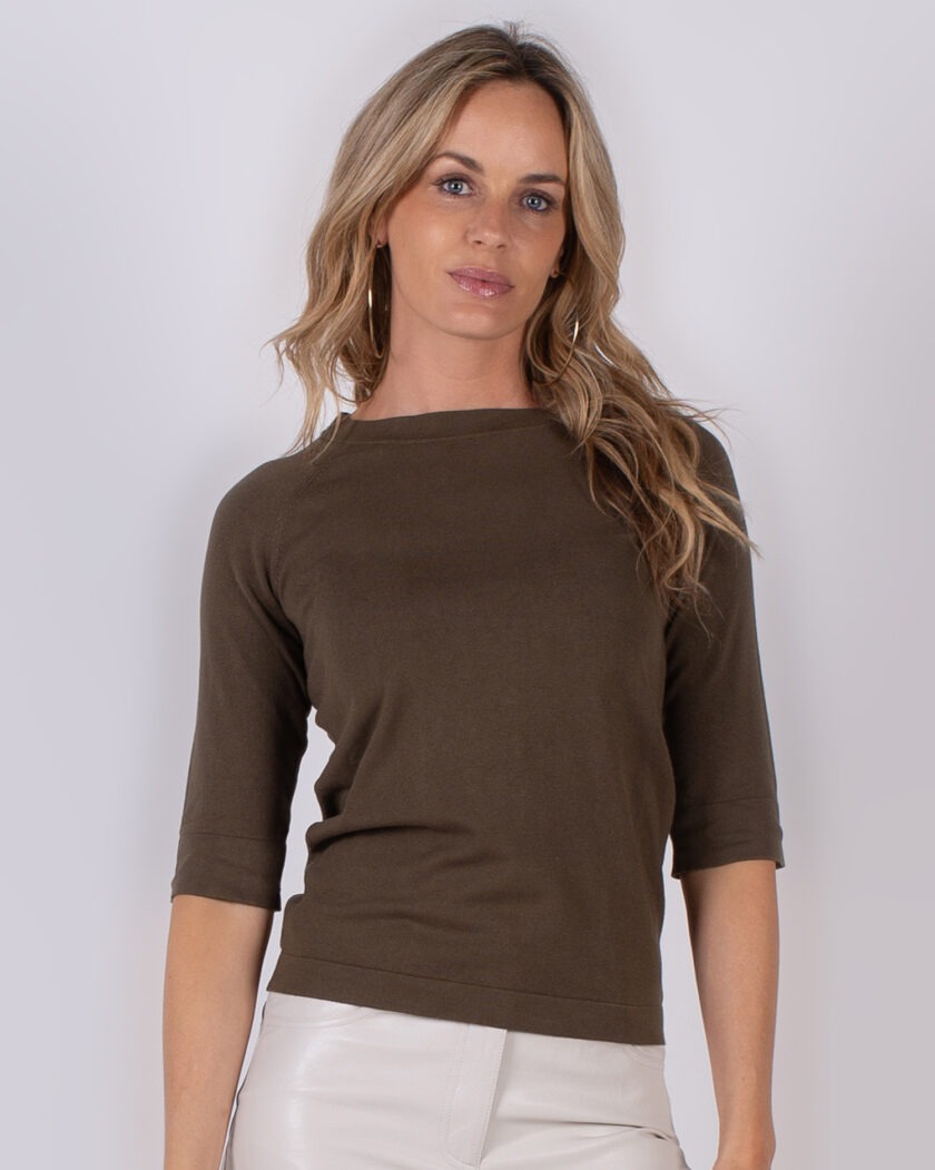 Vrouw draagt een donkergroen shirt met driekwartsmouwen uit de Studio AW25-26 collectie.