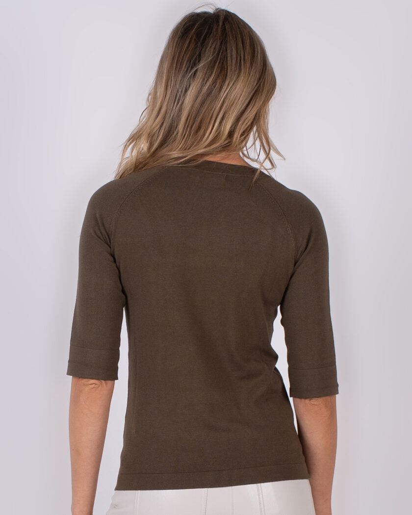 Achteraanzicht van een vrouw die een donkergroen, halfmouwig shirt uit de Studio AW25-26 collectie draagt.