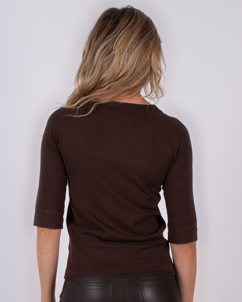 Vrouw van achteren in een donkerbruin shirt met halve mouwen uit de Studio AW25-26 collectie.
