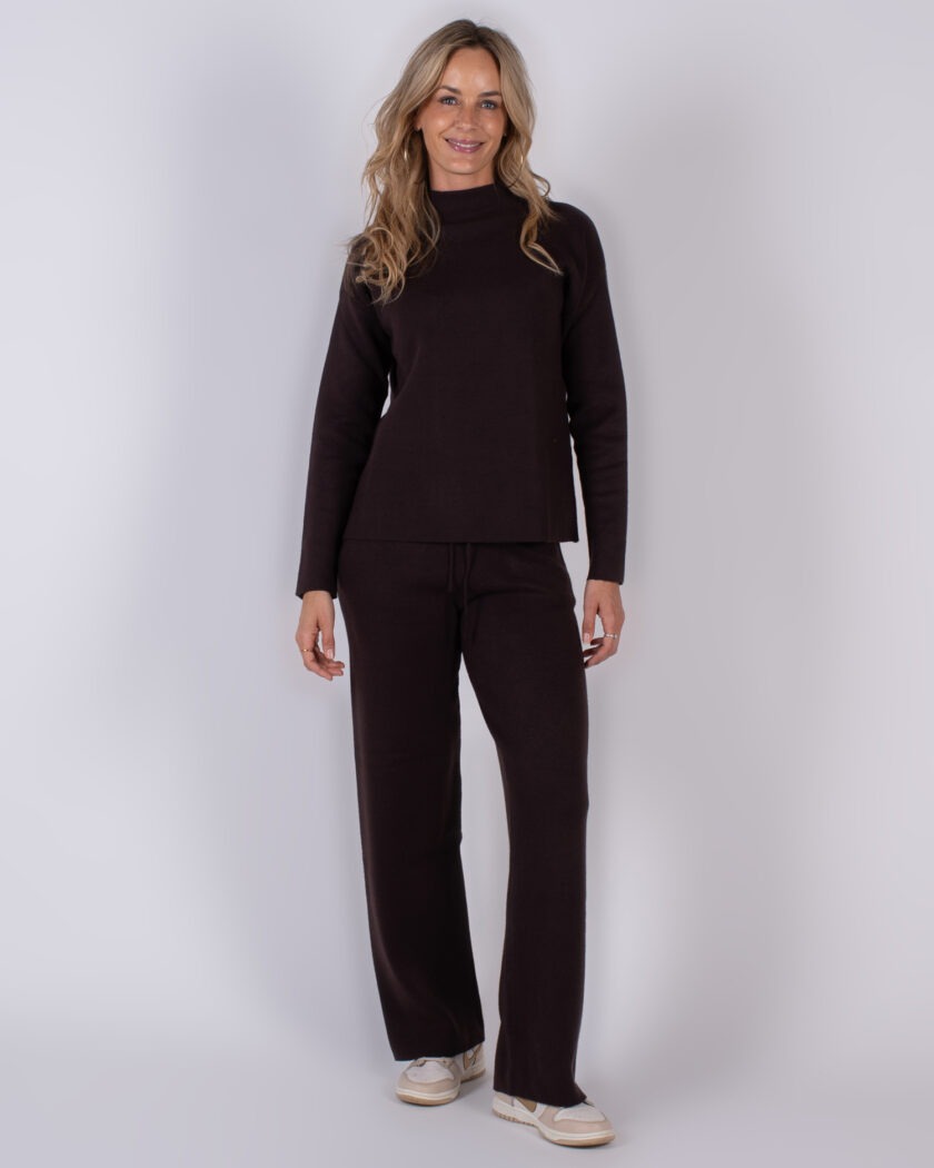Vrouw draagt een donkerbruine loungetop met bijpassende broek uit de Studio AW25-26 collectie.