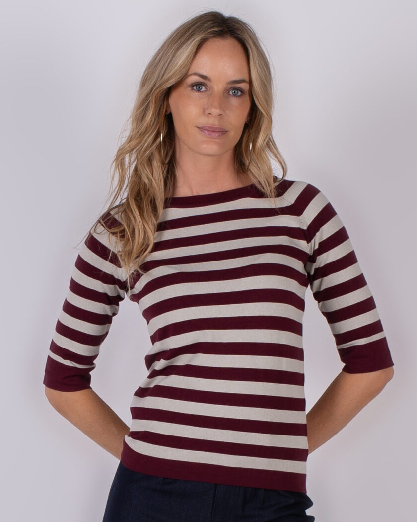 Vrouw draagt een bordeauxrood met beige gestreepte top met driekwartmouwen uit de Studio AW25-26 collectie.