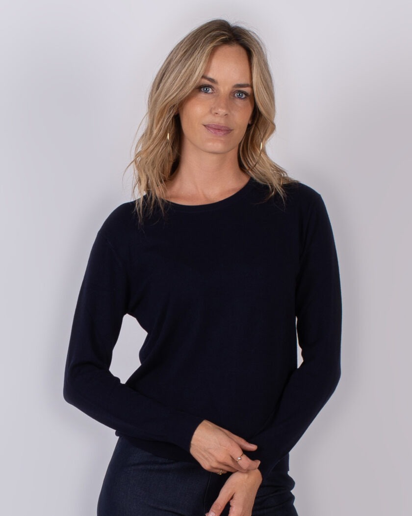 Vrouw draagt een donkerblauwe, lange mouwen trui uit de Studio AW25-26 collectie.