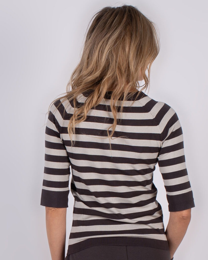 Vrouw van achteren in een zwart-grijs gestreepte trui met halflange mouwen uit de Studio AW25-26 collectie.