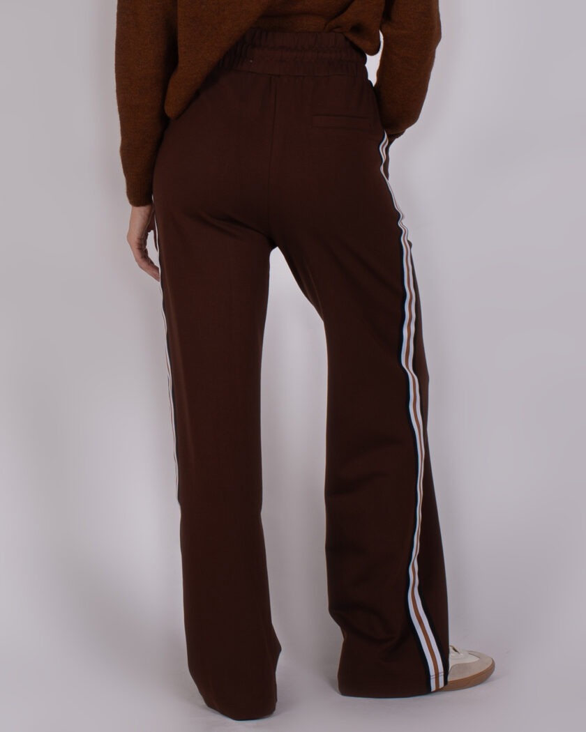 Bruine Studio AW25-26-121 broek met wijde pijpen en sportieve zijstrepen, gezien van de achterkant.