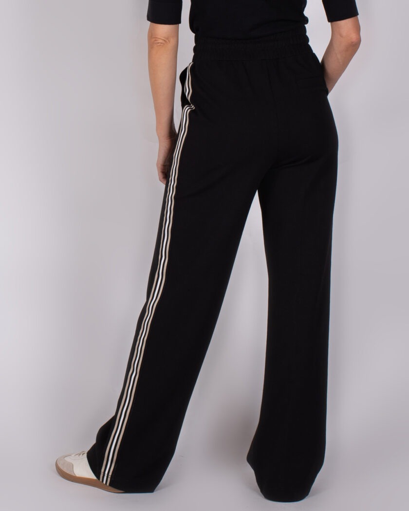 Zwart wijde broek met witte zijstrepen, achteraanzicht.