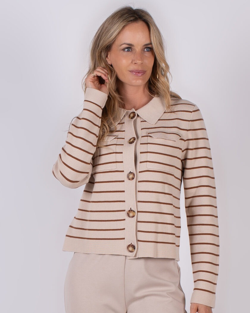 Vrouw draagt een beige vest met bruine horizontale strepen en grote knopen uit de Studio AW25-26 collectie.