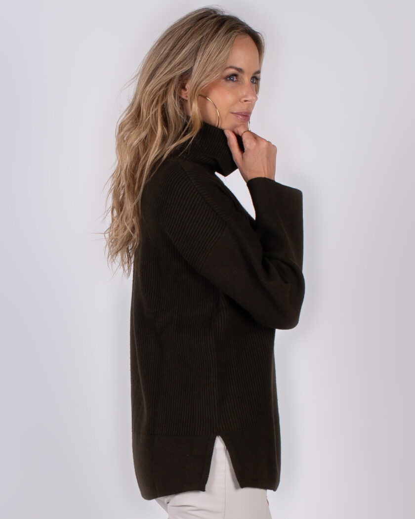 Vrouw in profiel draagt een donkerbruine coltrui uit de Studio AW25-26 collectie.
