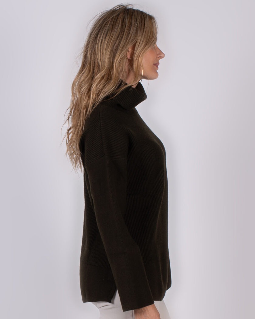 Vrouw in profiel met lang blond haar draagt een donkerbruine coltrui uit de Studio AW25-26 collectie.