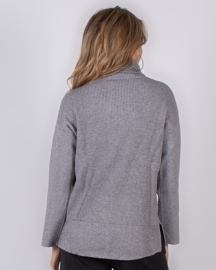 Vrouw van achteren in grijze, geribde trui uit de Studio AW25-26 collectie.
