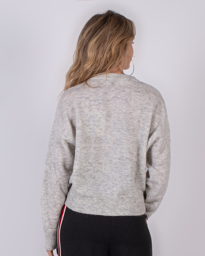 Vrouw van achteren in een grijze wollen trui uit de Studio AW25-26 collectie.