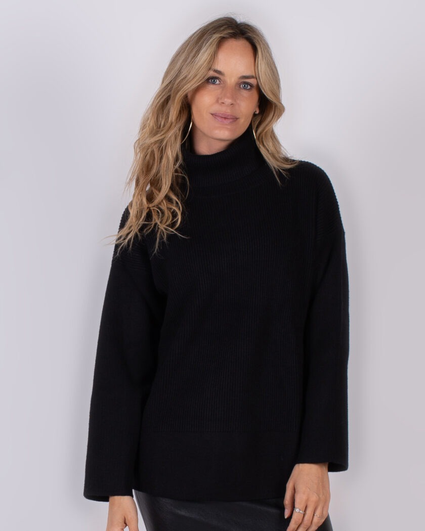 Vrouw draagt een zwarte coltrui met lange mouwen uit de Studio AW25-26 collectie.