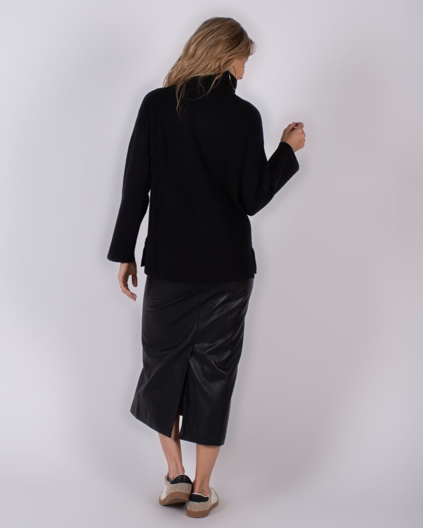 Vrouw in zwarte coltrui en zwarte midi-leren rok gezien van achteren, uit de Studio_AW25-26#2-68 collectie.