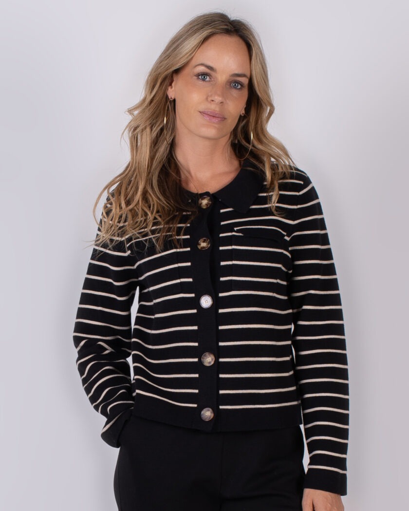 Vrouw draagt een zwart-wit gestreept vest met grote knopen uit de Studio AW25-26 collectie.