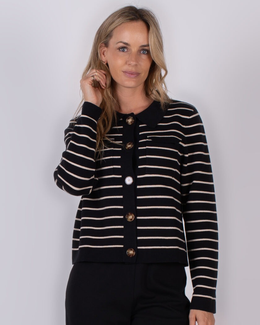 Vrouw draagt een zwart-wit gestreept vest met grote knopen uit de Studio AW25-26 collectie.