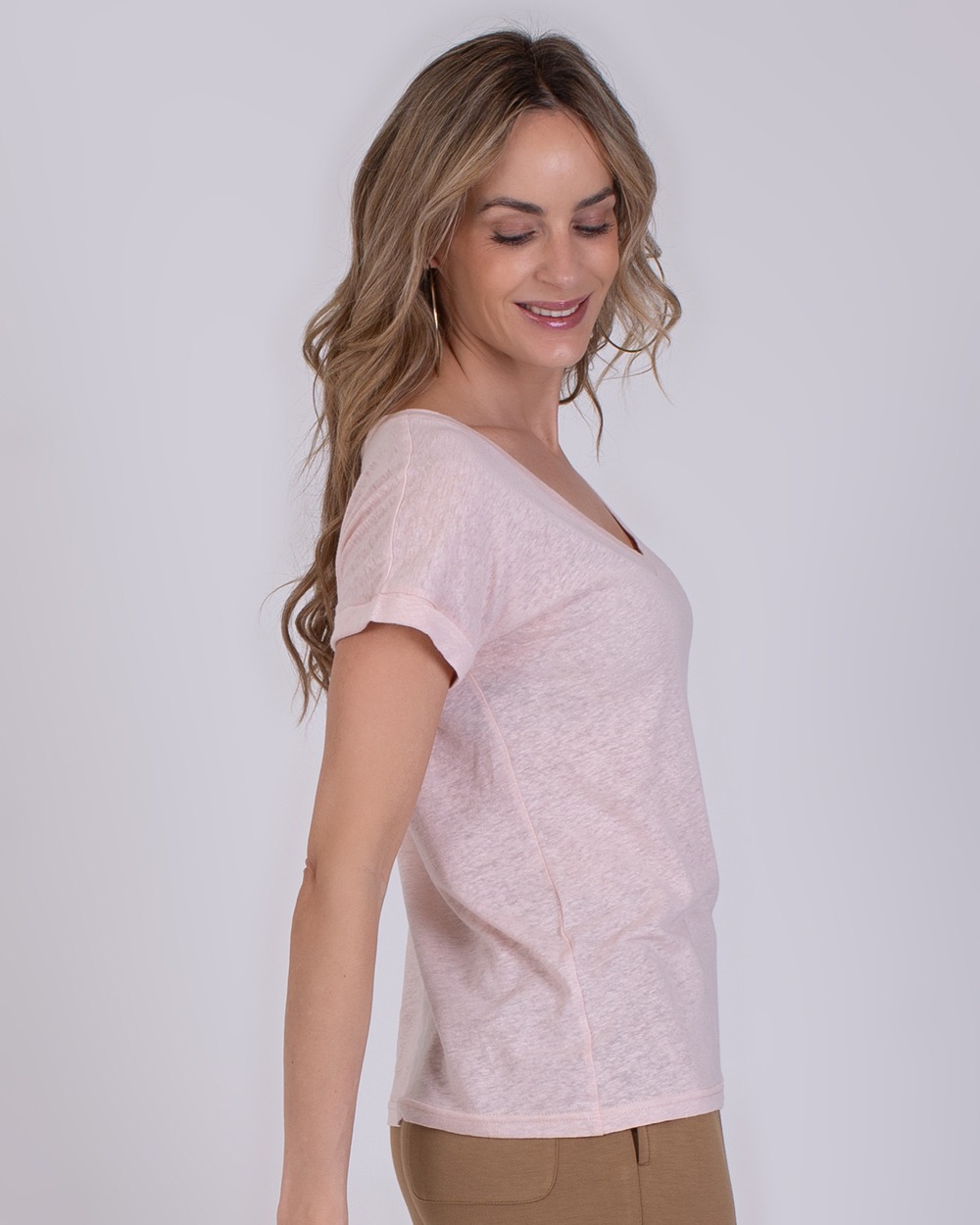 Athene old pink 1 Vrouw draagt een lichtroze Athene T-shirt met V-hals, gezien vanaf de zijkant.