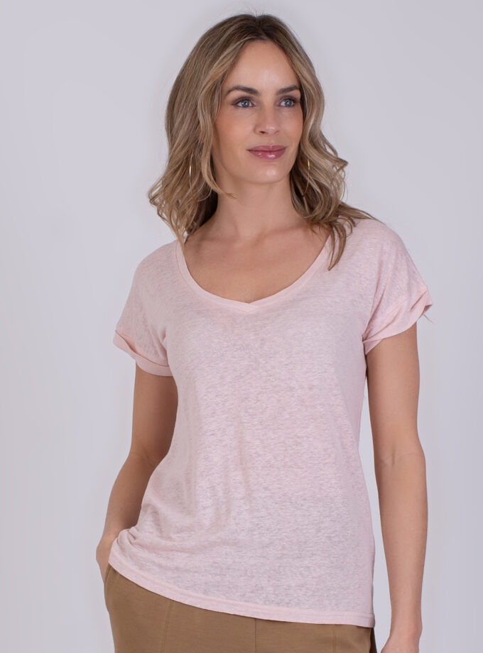 Vrouw draagt een lichtroze T-shirt met V-hals en opgerolde mouwen, model Athene old pink.