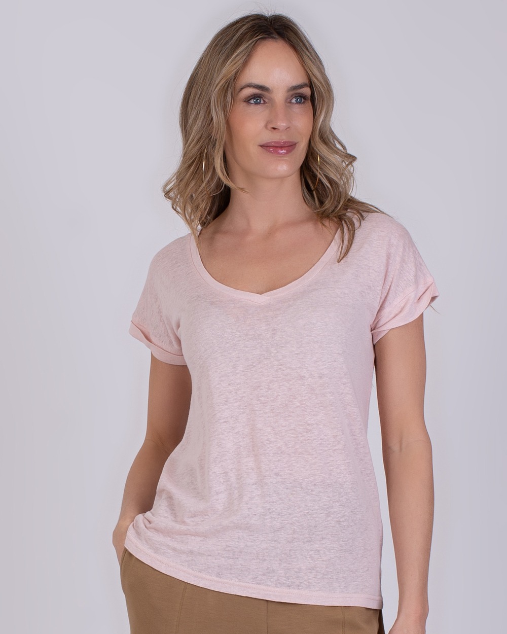 Athene old pink 2 Vrouw draagt een lichtroze T-shirt met V-hals en opgerolde mouwen, model Athene old pink.