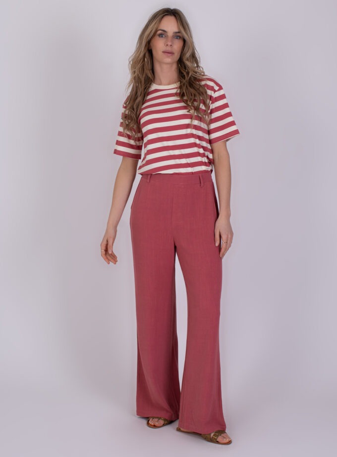 Vrouw draagt een rood-wit gestreept T-shirt en losse frambooskleurige broek uit de Istanbul Raspberry collectie.