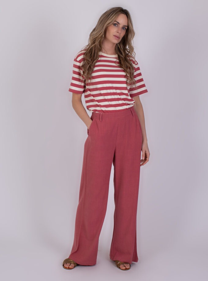 Vrouw draagt een gestreept T-shirt en losse framboosrode broek genaamd 'Istanbul raspberry 2'.