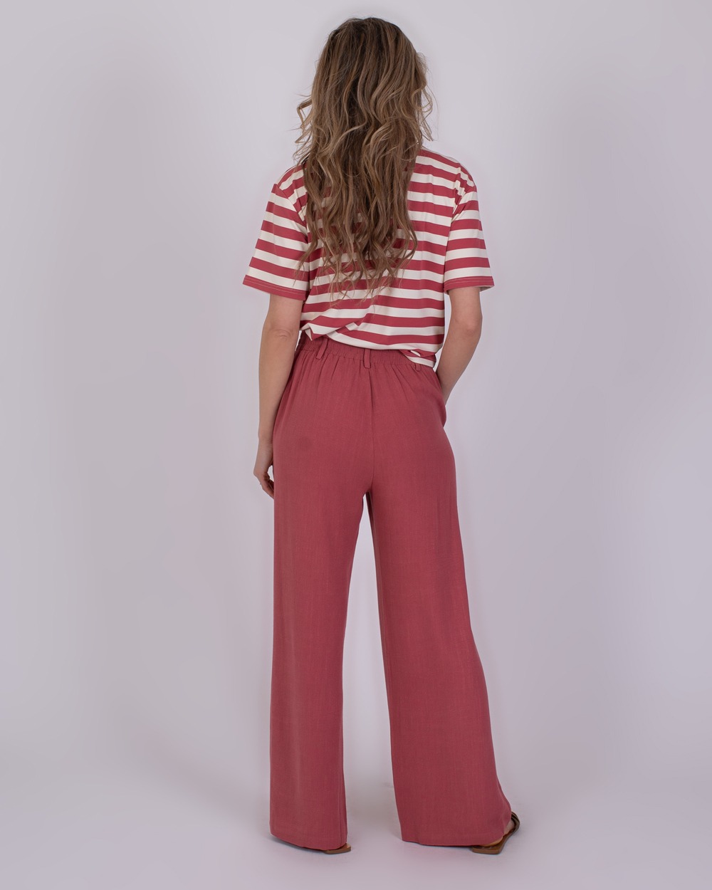 Istanbul raspberry 7 Vrouw van achteren in een rood-wit gestreept T-shirt en losse frambooskleurige broek genaamd "Istanbul raspberry".