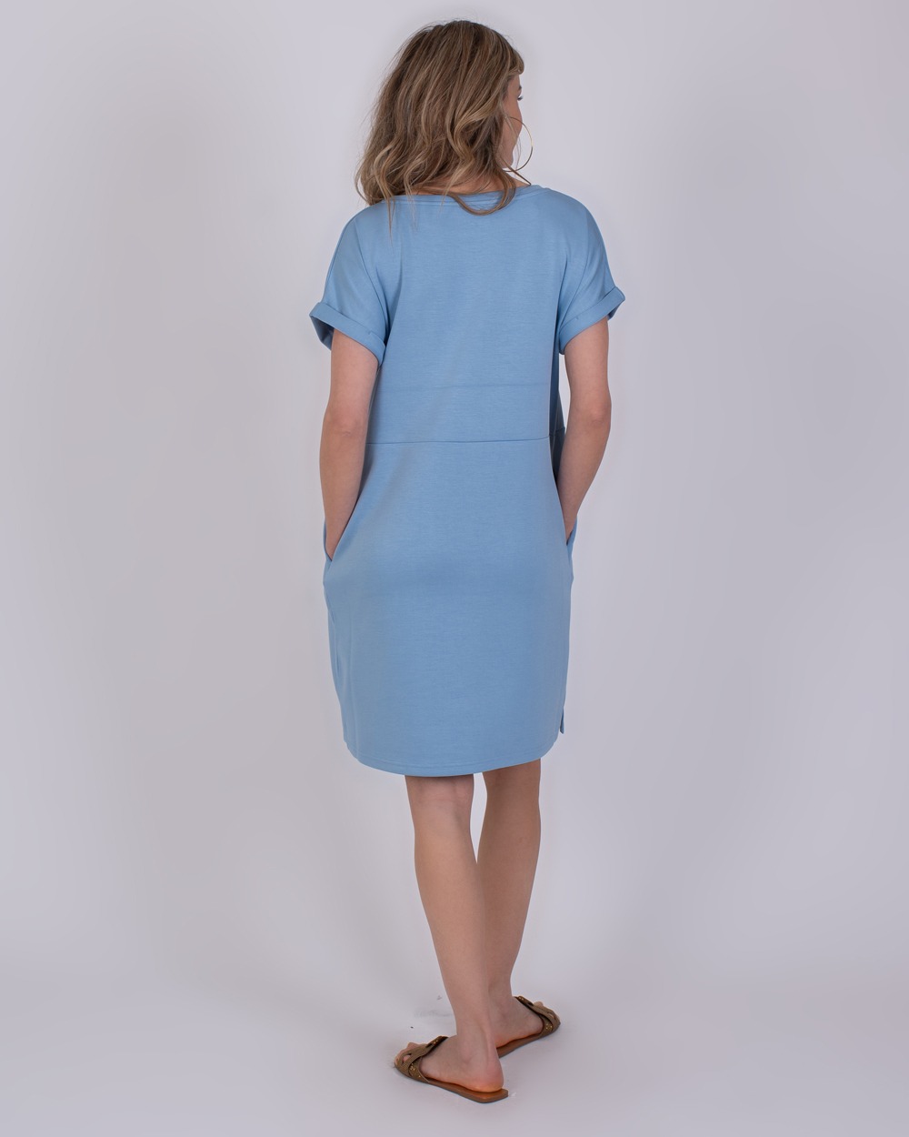 Liverpool soft blue 5 Vrouw van achteren in een lichtblauwe Liverpool-jurk met korte mouwen en insteekzakken.