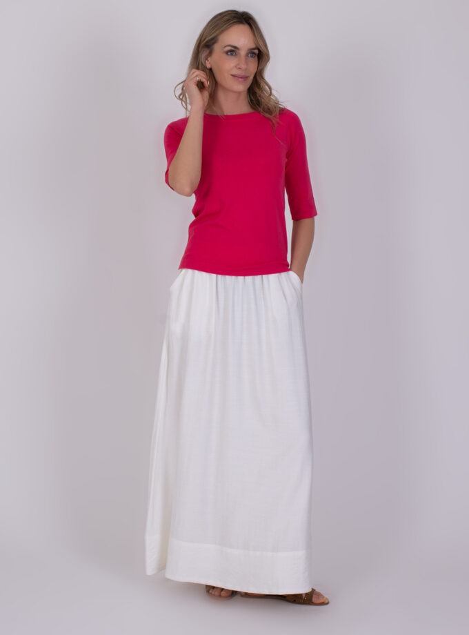 Vrouw in een fuchsia Moscow top met halflange mouwen en een lange witte rok.