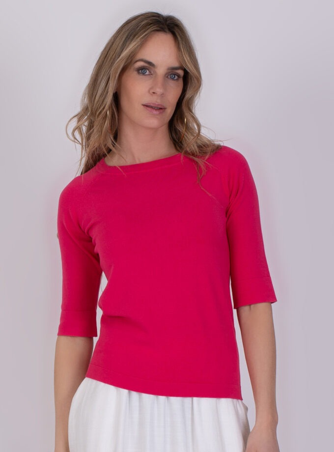 Vrouw draagt een fuchsia top met driekwartsmouwen uit de Moscow fuchsia 4 collectie.