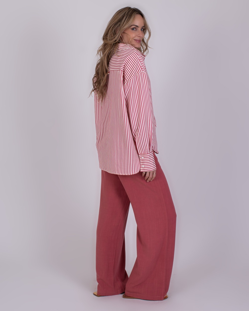 Almeria old pink 5 Vrouw in rood-wit gestreepte blouse en wijde oudroze broek uit de Almeria old pink collectie.