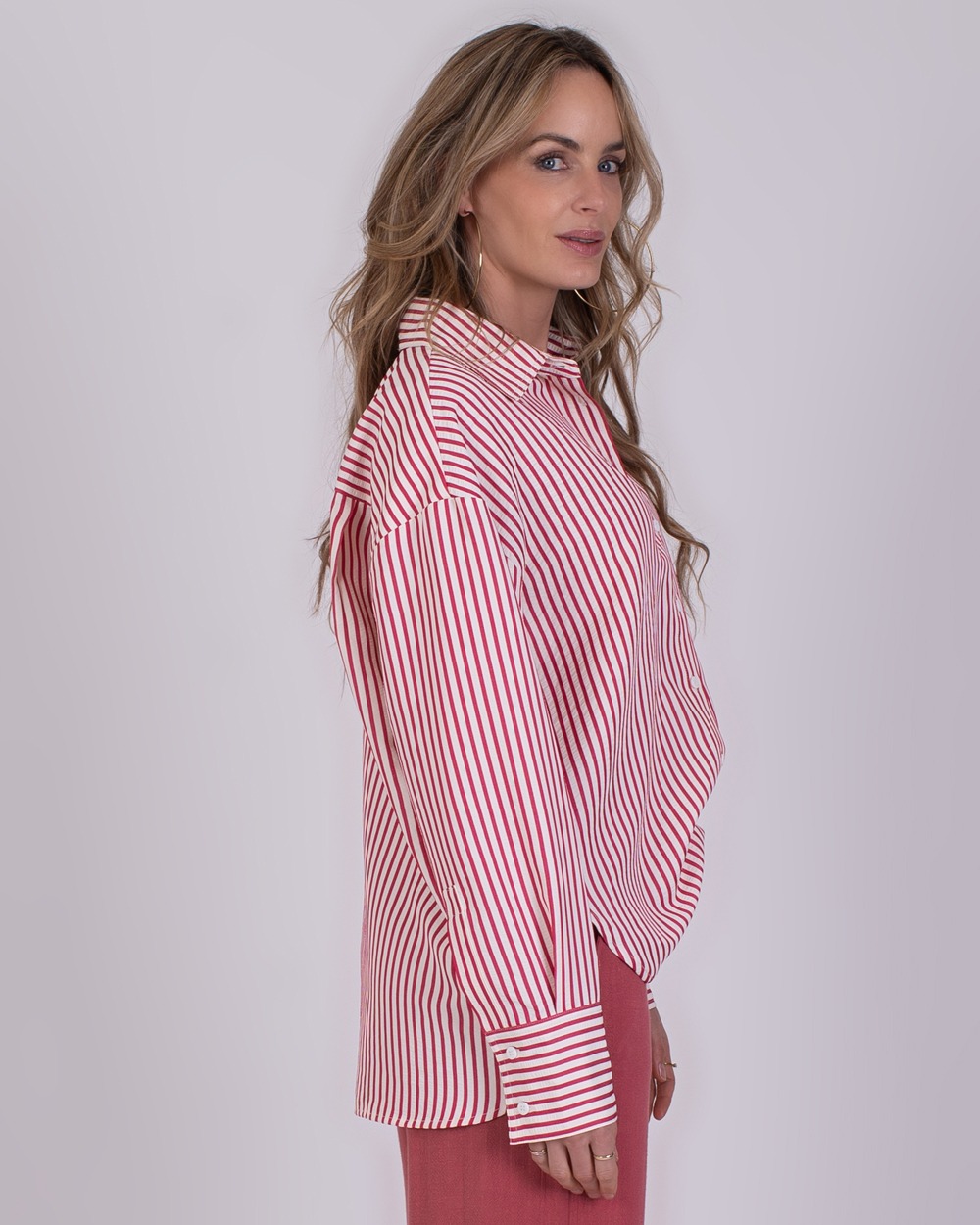 Almeria old pink 6 Vrouw in een rood-wit gestreeerde blouse en oudroze broek uit de Almeria old pink 6 collectie.