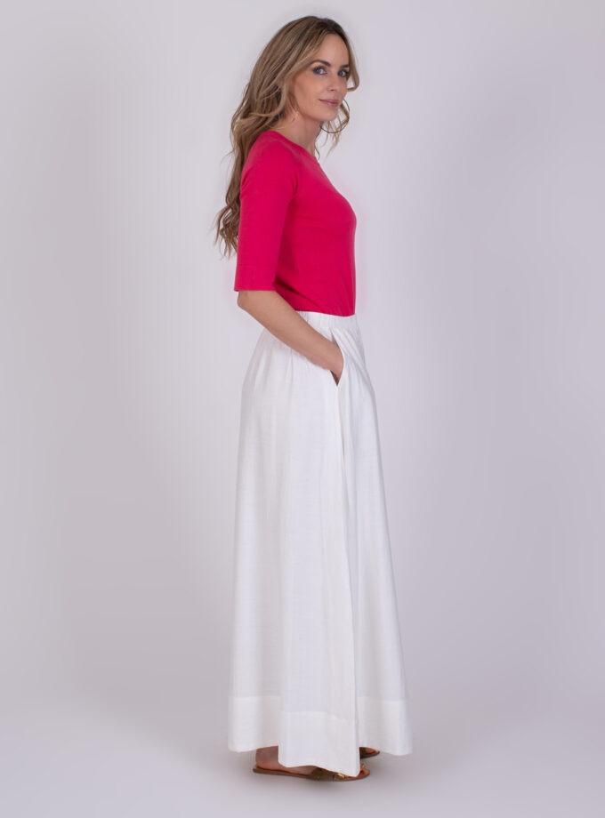 Vrouw draagt een felroze top en een wijde off-white Altos broek met elastische tailleband.