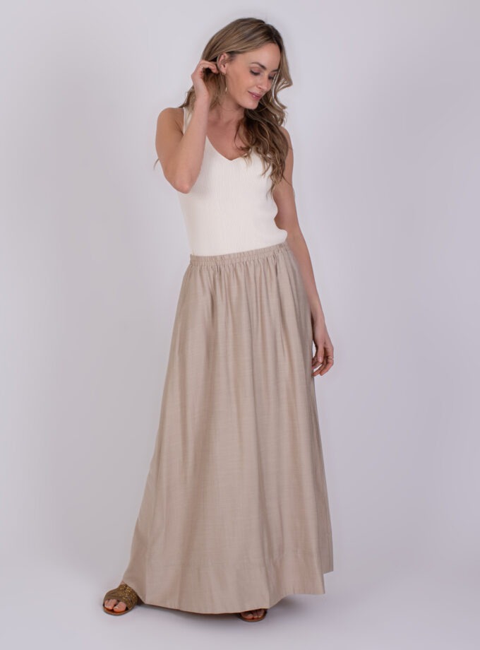 Vrouw draagt een witte top en een lange beige rok genaamd Altos Pale 3.
