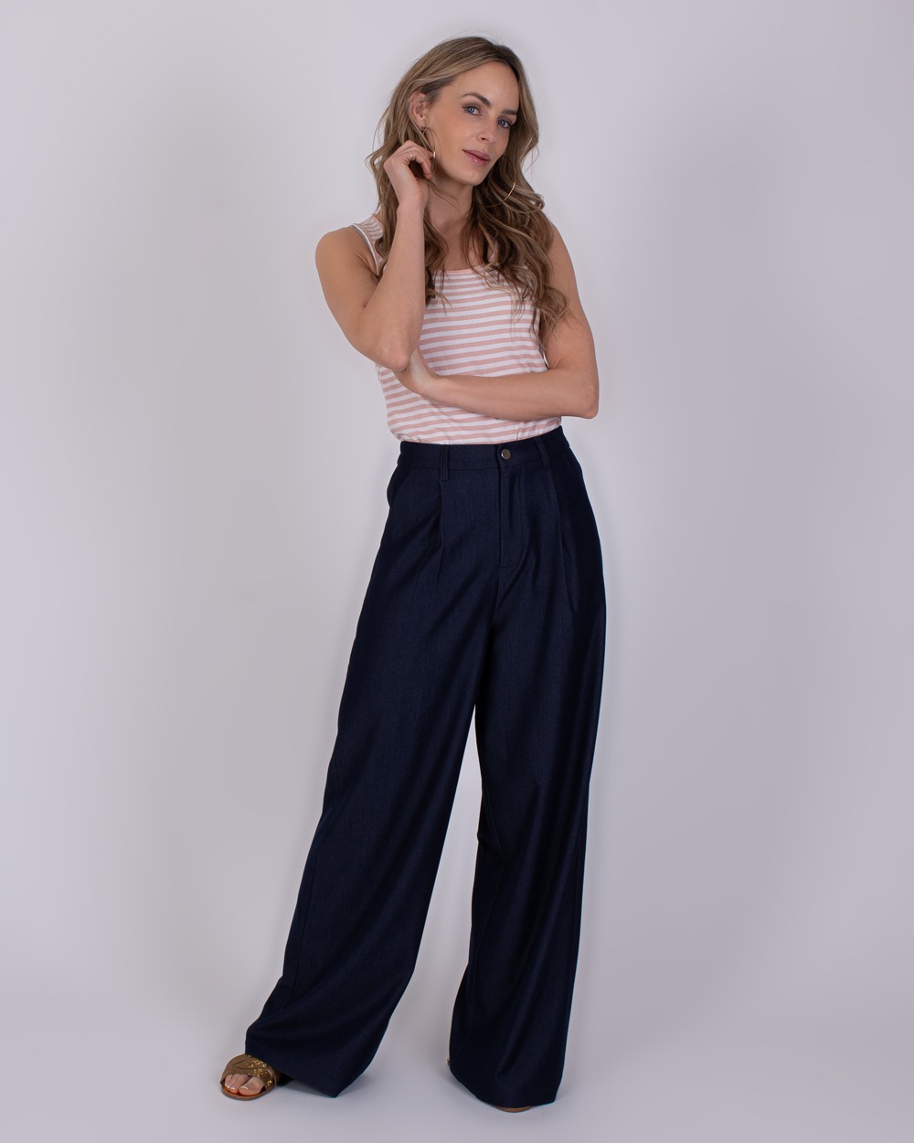 Bergamo Indigo blue 3 Vrouw draagt wijde Bergamo Indigo blue broek met een lichtroze gestreepte top.