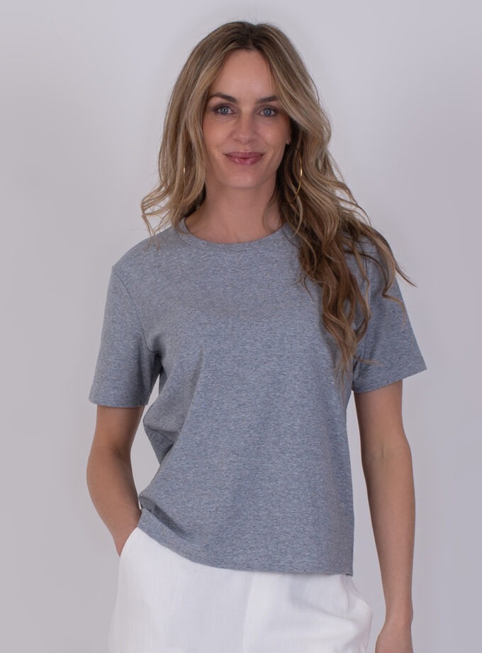 Vrouw draagt een grijs Denver T-shirt met korte mouwen en een witte broek.